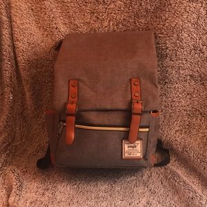 Grey backpack with brown and gold accents